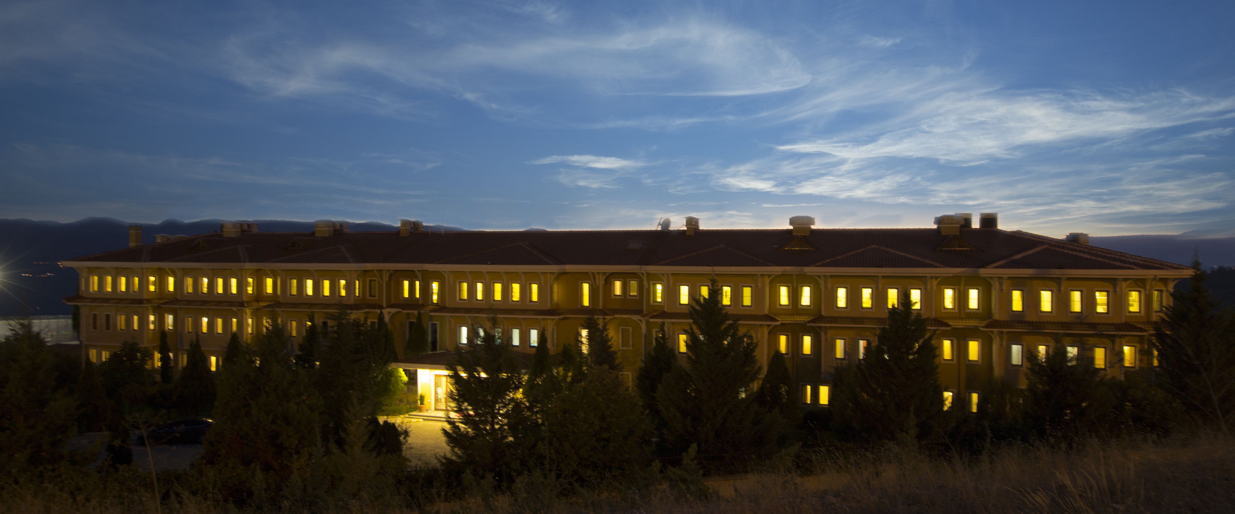 A large, multi-story building with numerous windows, likely a hotel or resort, featuring a symmetrical facade and a flat roof.
