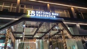 The exterior of Patong Bay Residence with a modern design, featuring a prominent illuminated sign and string lights. - Patong Bay Residence  (Patong)