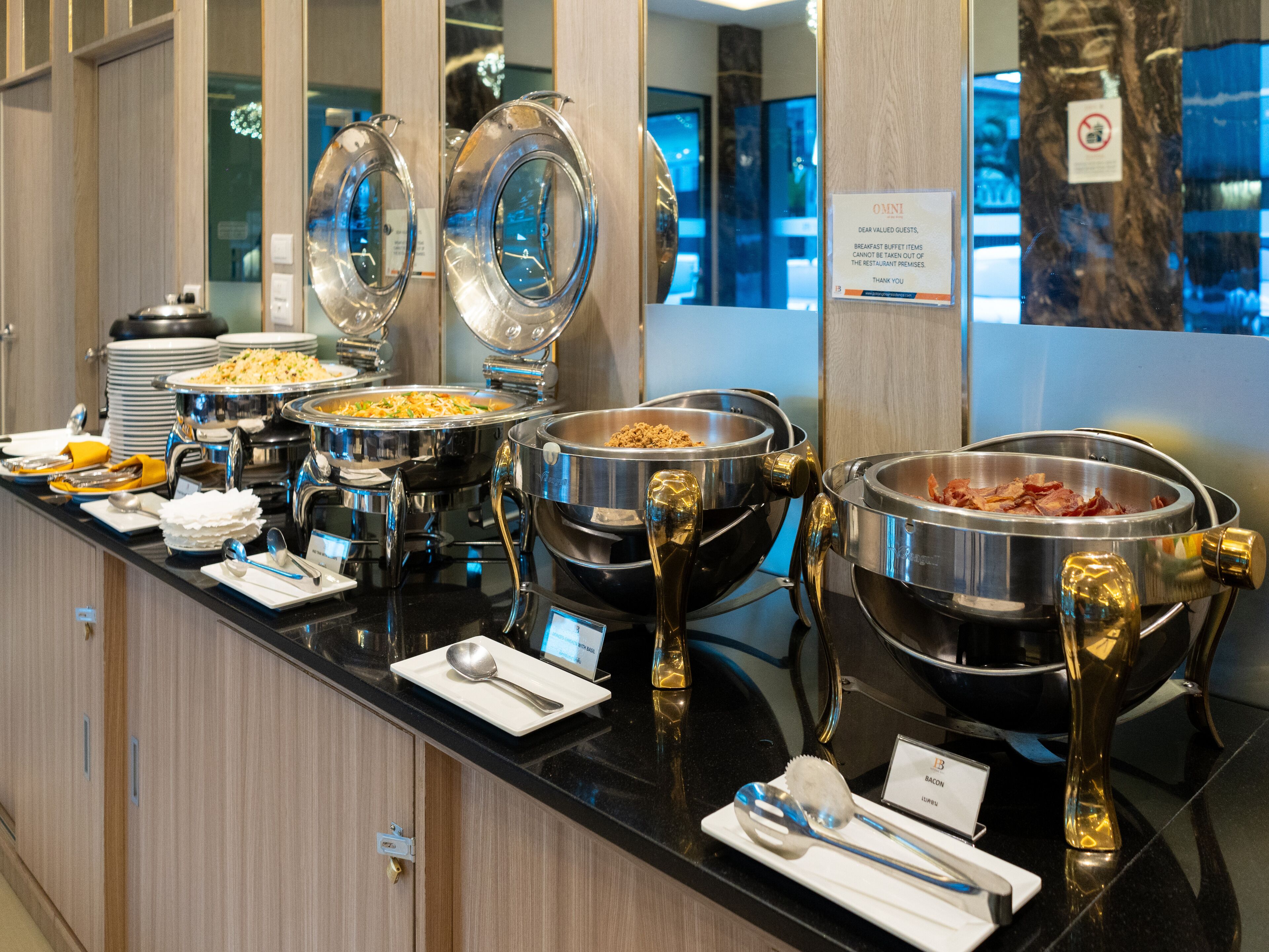 A buffet with various food items and utensils.