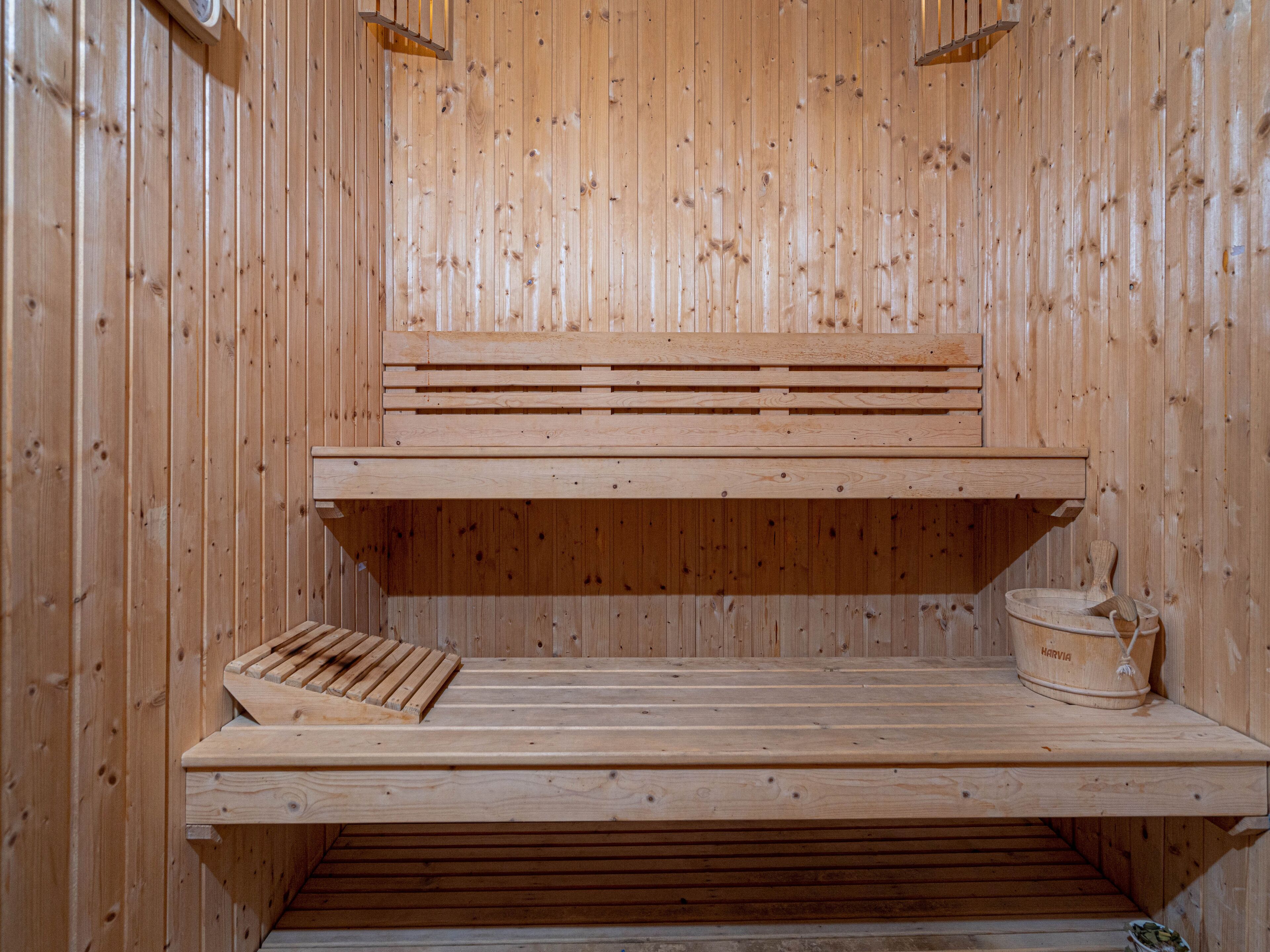 A wooden sauna with two benches and a small table.