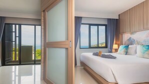 A hotel room with a large bed, a view of the outdoors, and a balcony. - Patong Bay Residence  (Patong)