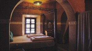 Una habitación con cama con dosel, una ventana y un candelabro.