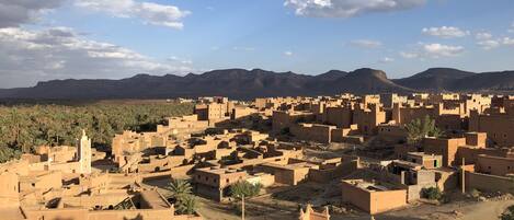 A desert town with traditional architecture, including a prominent minaret and a mosque.