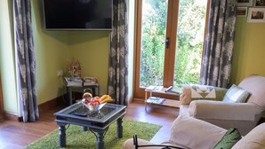 A living room with a television, a dining table, and a sofa. - Field View B&B (Goole)