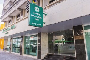Exterior del Hotel Nacional Inn, con un cartel llamativo, ventanas grandes y una entrada visible.