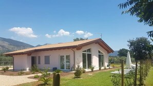 A single-story house with a tiled roof, large windows, and a well-maintained lawn. - Il Rifugio Del Tempo (Roccasecca)