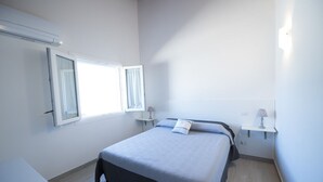 A bedroom with a bed, a window, a bedside table, and a nightstand. - Il Rifugio Del Tempo (Roccasecca)