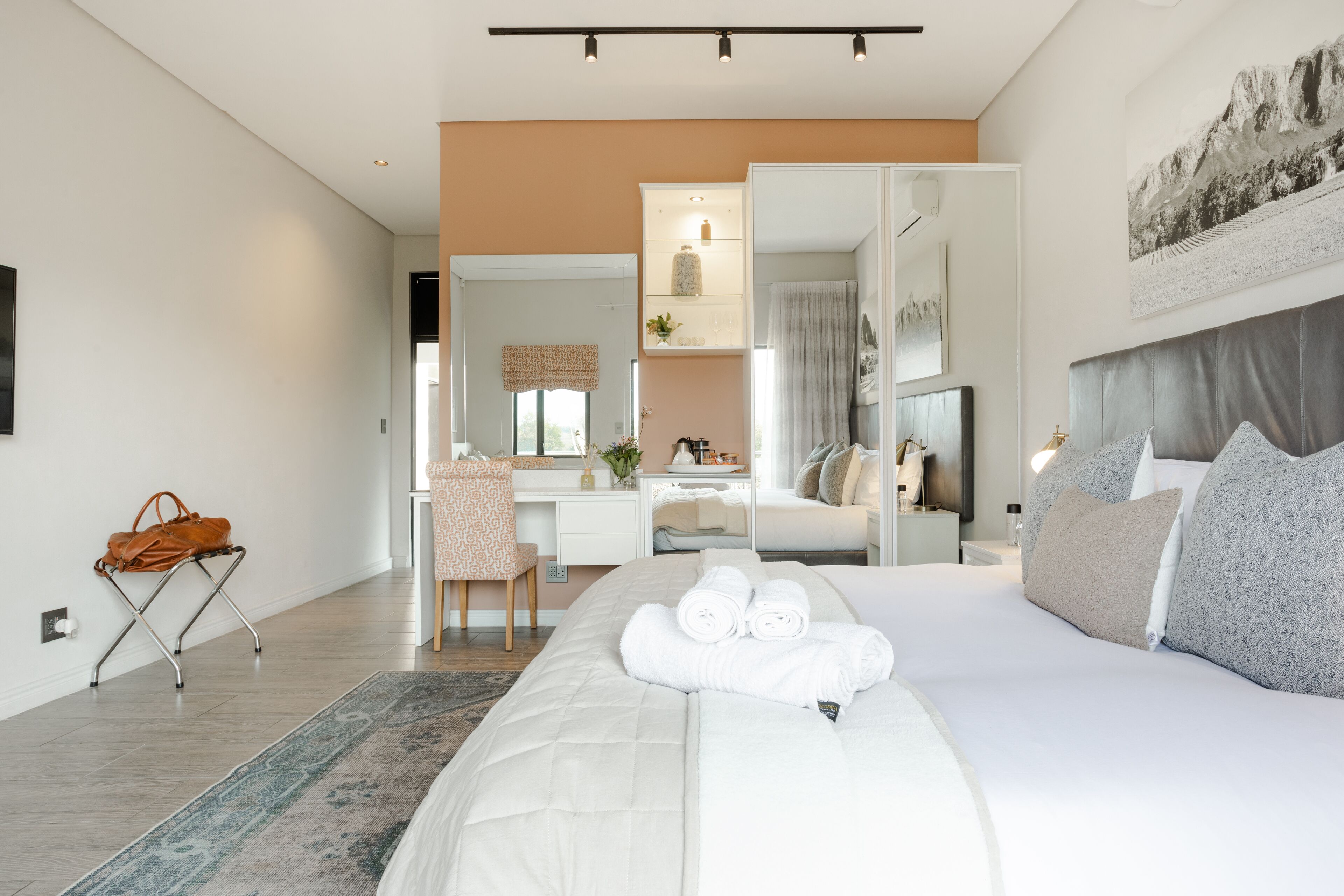 Una camera d'albergo moderna con un letto grande, una scrivania e una sedia.