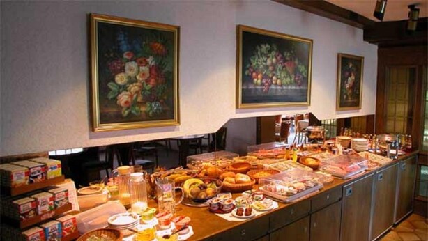 Un bufé con diversas opciones de comida y un cuadro de flores en la pared.