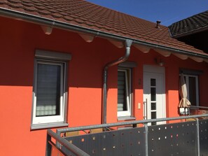 A red building with a tiled roof, a white door, and two windows. - Gästehaus Durst (Rust)