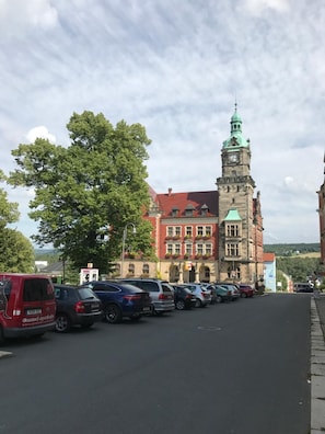 Ruas com carros estacionados e um edifício histórico com torre do relógio.