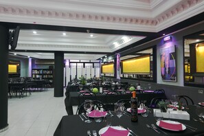 A banquet hall with tables set for dining, featuring black tablecloths, white plates, and pink napkins. - Cafe Bar Hotel Jefi (Jaraíz de la Vera)