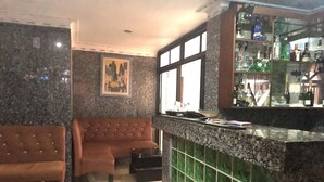 Zona de bar amb un taulell, un sofà i un quadre a la paret.