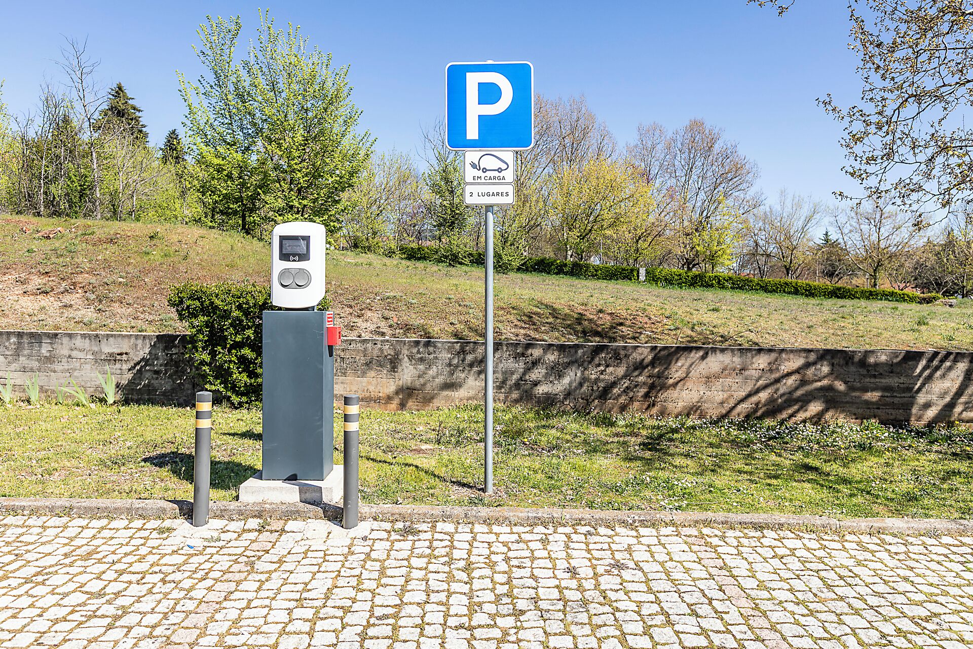 Un espace de stationnement équipé d’un kiosque de paiement et d’un panneau indiquant un emplacement de stationnement.