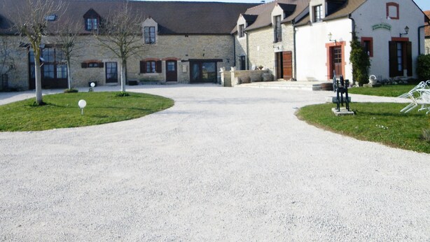 A building with a gravel driveway, stone walls, and a mix of brick and stucco exteriors. - La Ferme du Coucou (Prenois)
