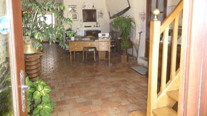 A home office with a desk, chair, and multiple potted plants. - La Ferme du Coucou (Prenois)