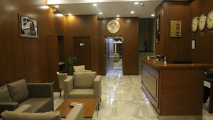 A hotel lobby with a reception desk, seating area, and a marble floor. - Erzincan Mesut Hotel (Erzincan)