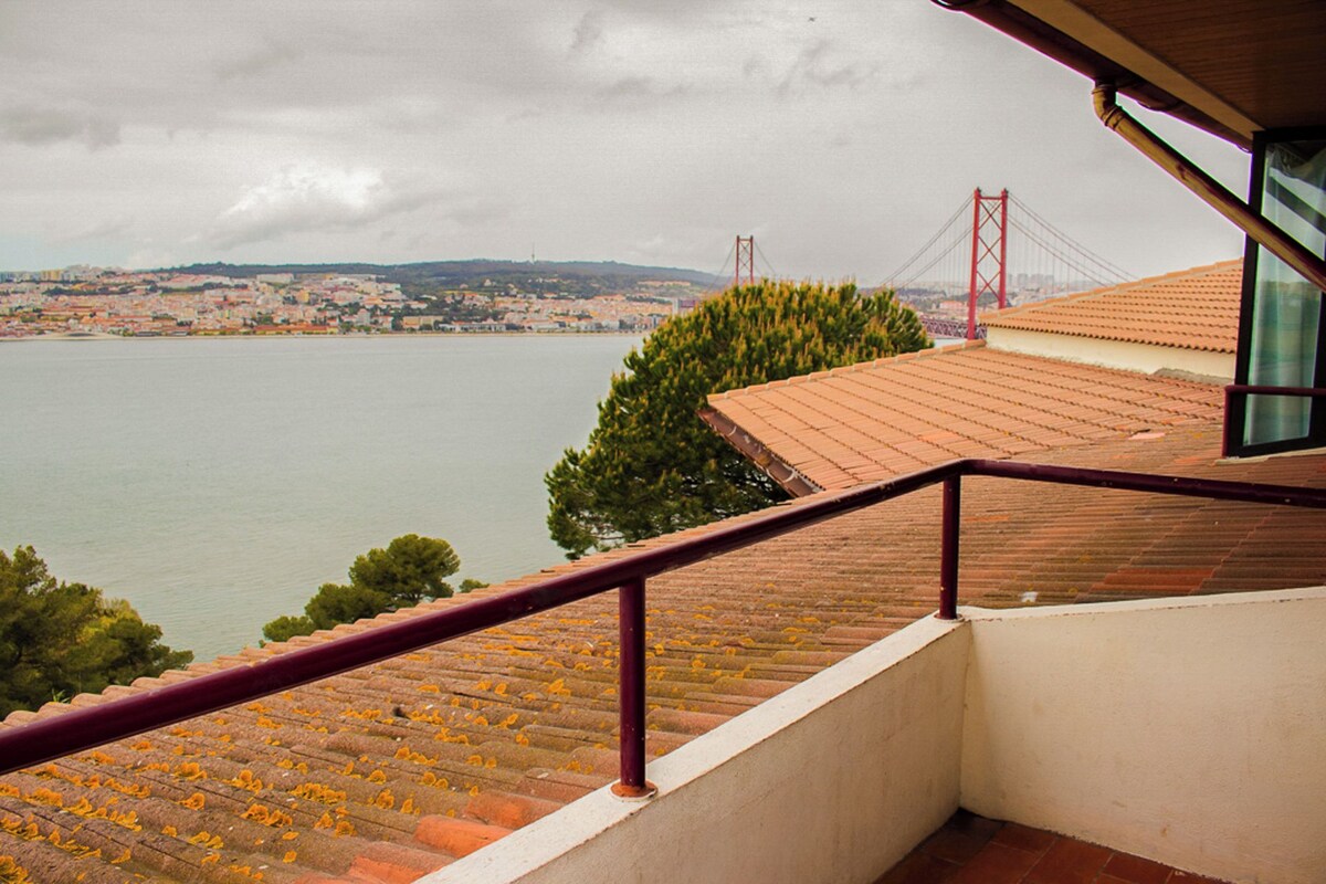 A view from a balcony overlooking a body of water with a bridge in the distance.