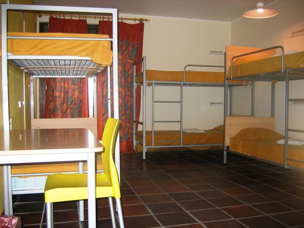 Et sovesal med køjesenge, et bord og stole.