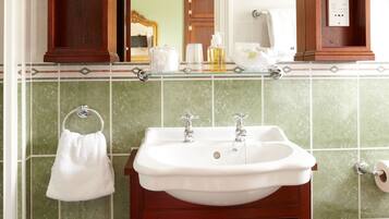 A bathroom with a wooden vanity, a white sink, and a mirror above it.
