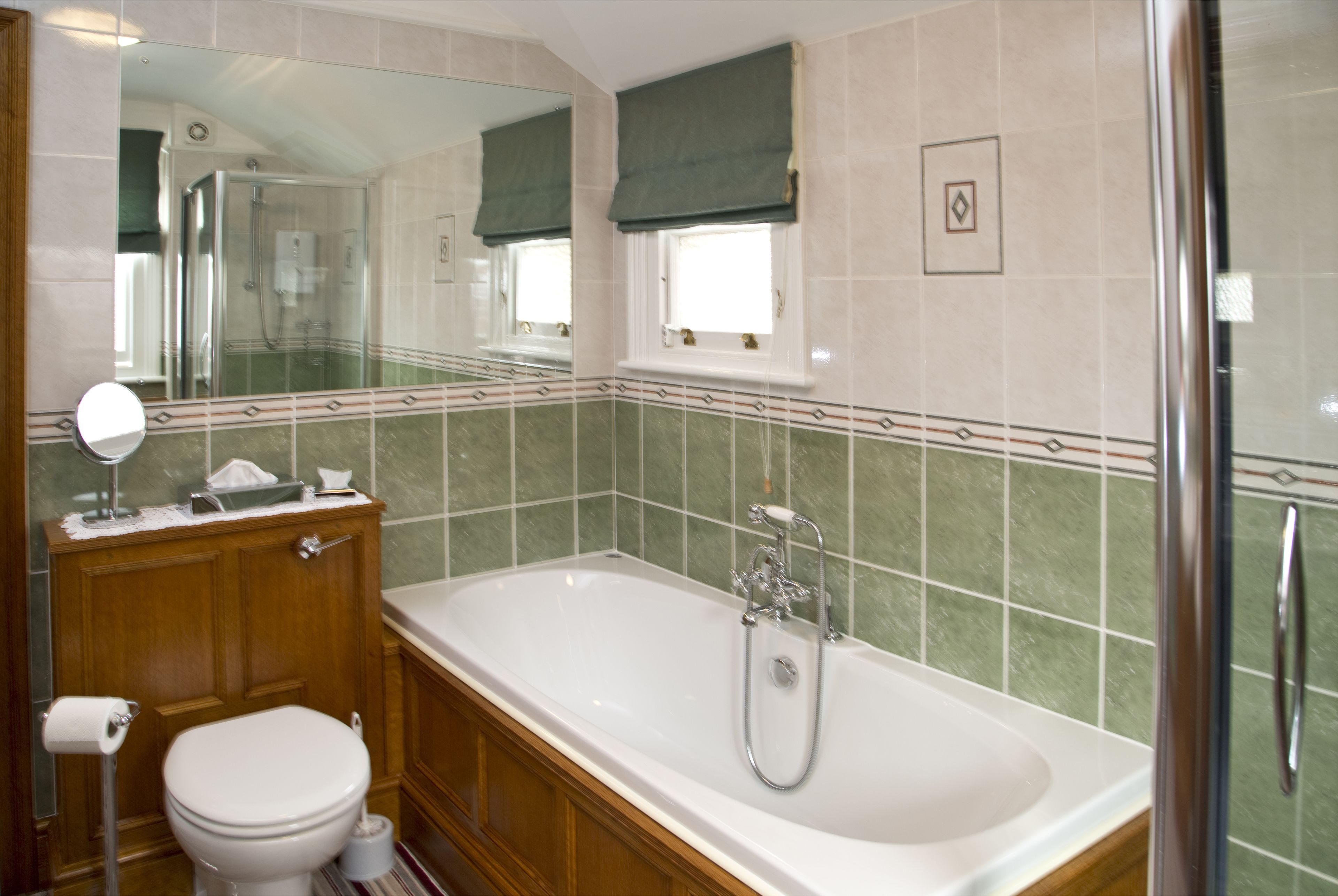 Ein Badezimmer mit Badewanne, Toilette, Waschtisch und einem großen Spiegel.