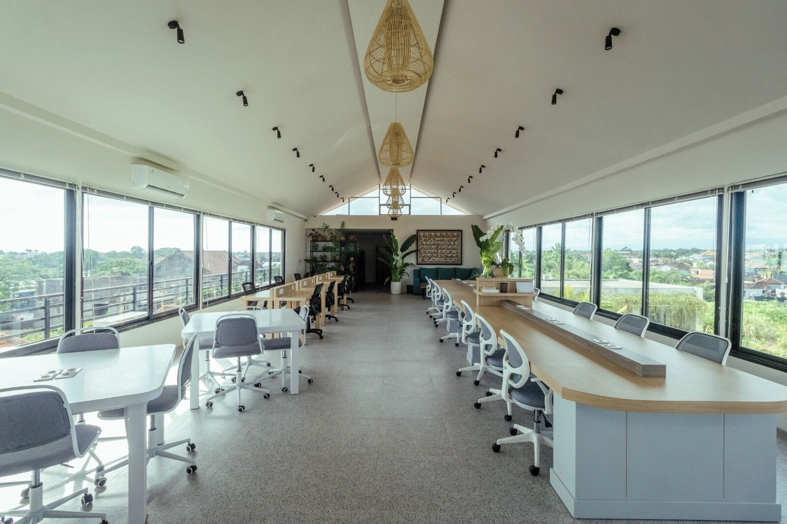 A modern office space with large windows, a long conference table, and a view of the city.