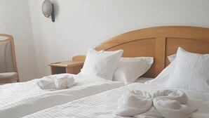 A hotel room with two beds, each with neatly folded towels and pillows. - Pension Nadia (Adorf)