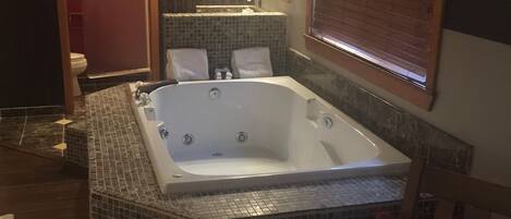 A bathroom with a large freestanding bathtub, a shower, and a toilet.
