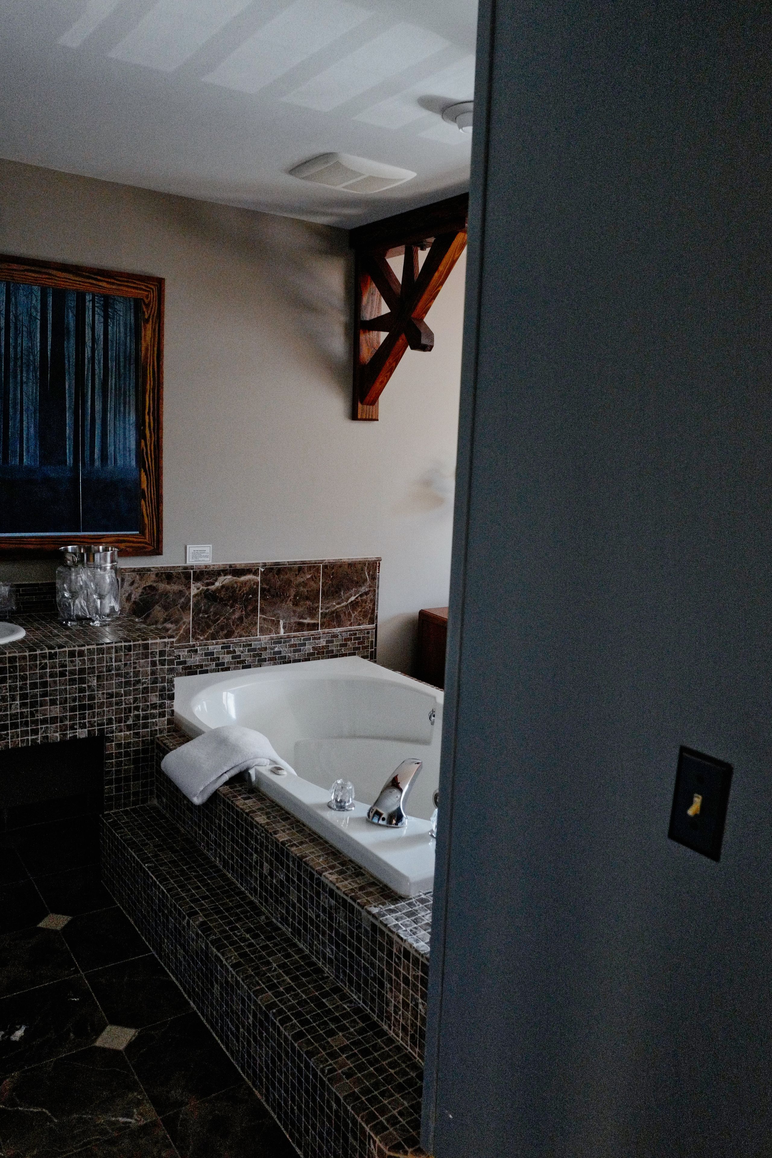 A modern bathroom with a large bathtub, a sink, and a mirror.