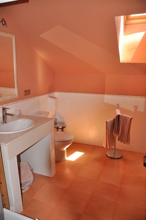 Casa de banho com lavatório, sanita e suporte para toalhas.