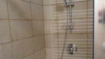 Een douche met een handdouche en een wandmengkraan.