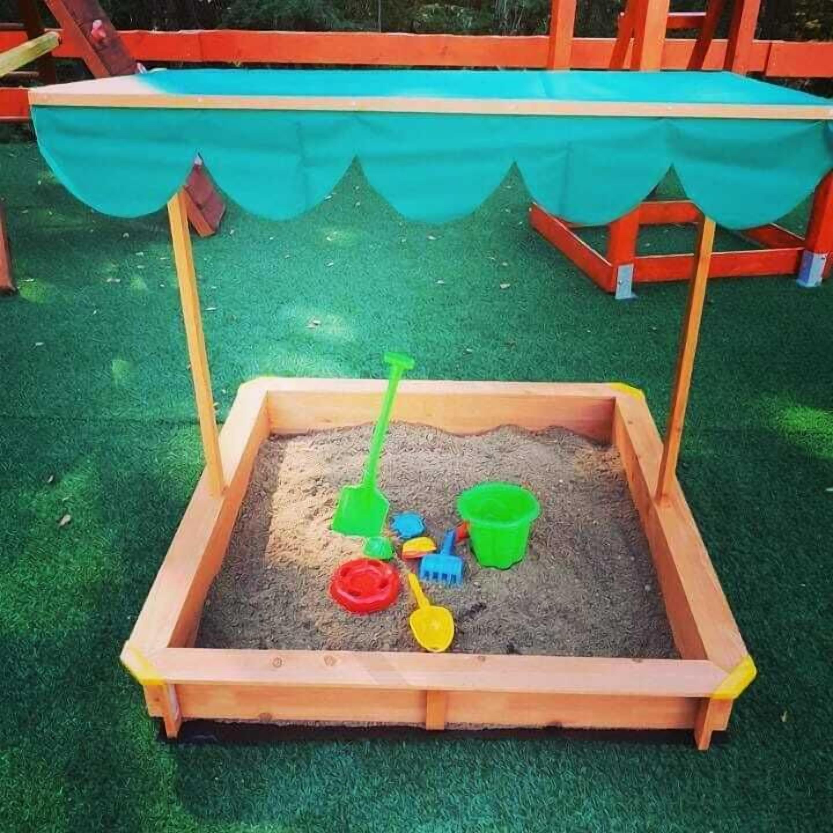 Ein Sandkasten mit Holzränder und einer grünen Plane darüber.