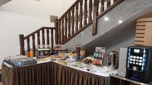 A buffet setup with various food items and a coffee machine. - Club Rezidence Pod Lučí Loučovice (Loucovice)