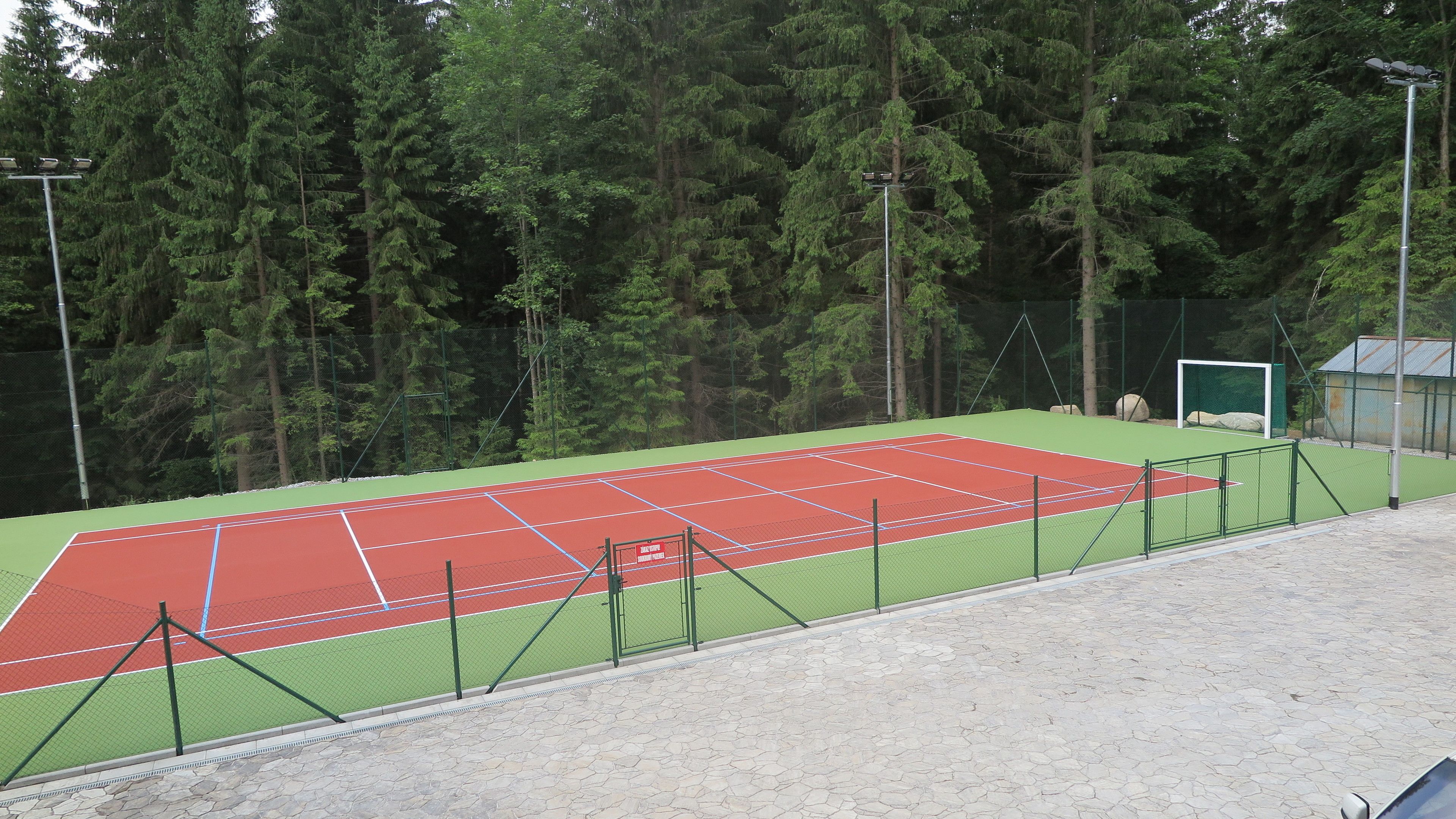 Una cancha de tenis rodeada de árboles.
