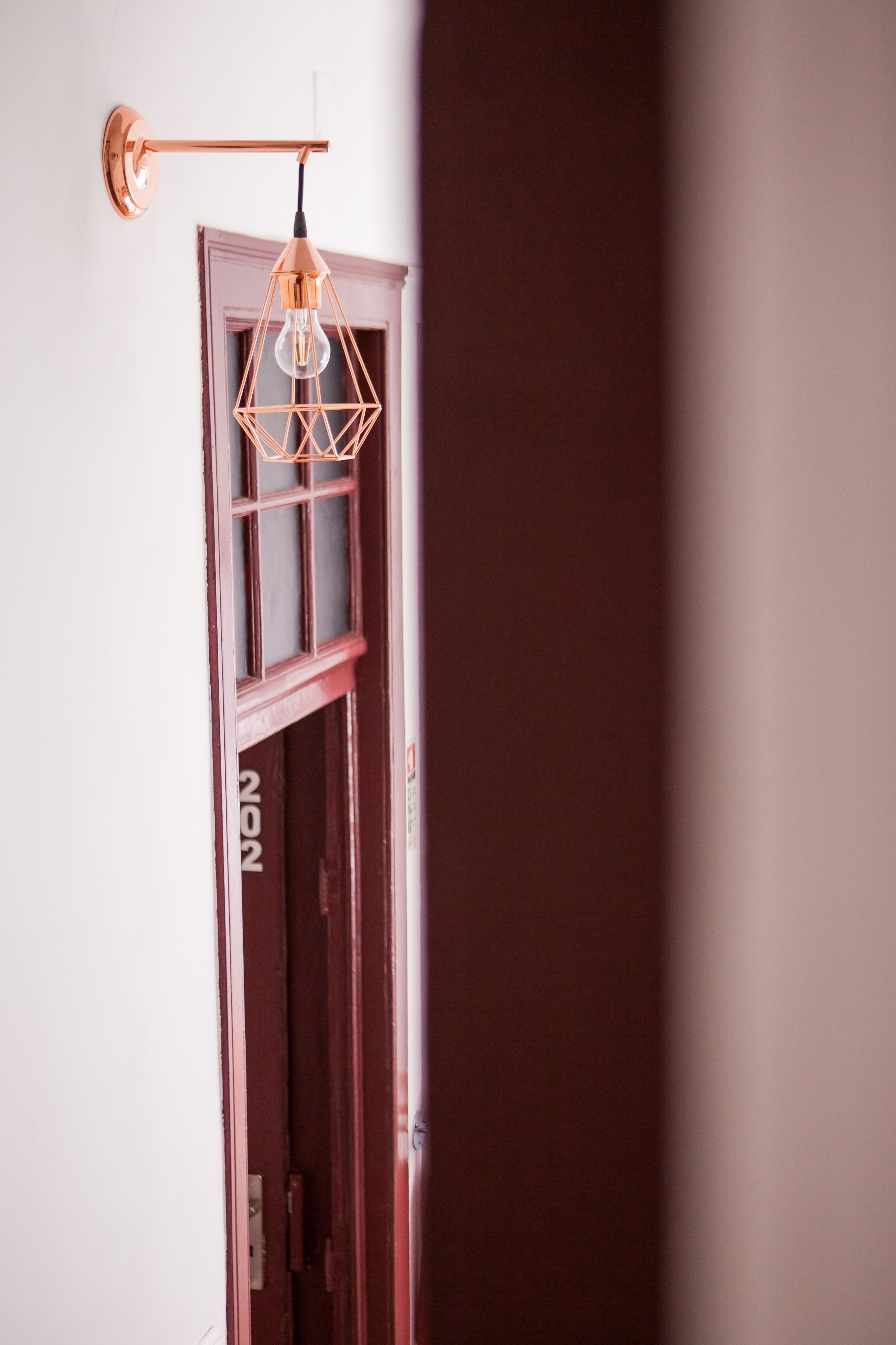 A door with a geometric light fixture and a visible door number.