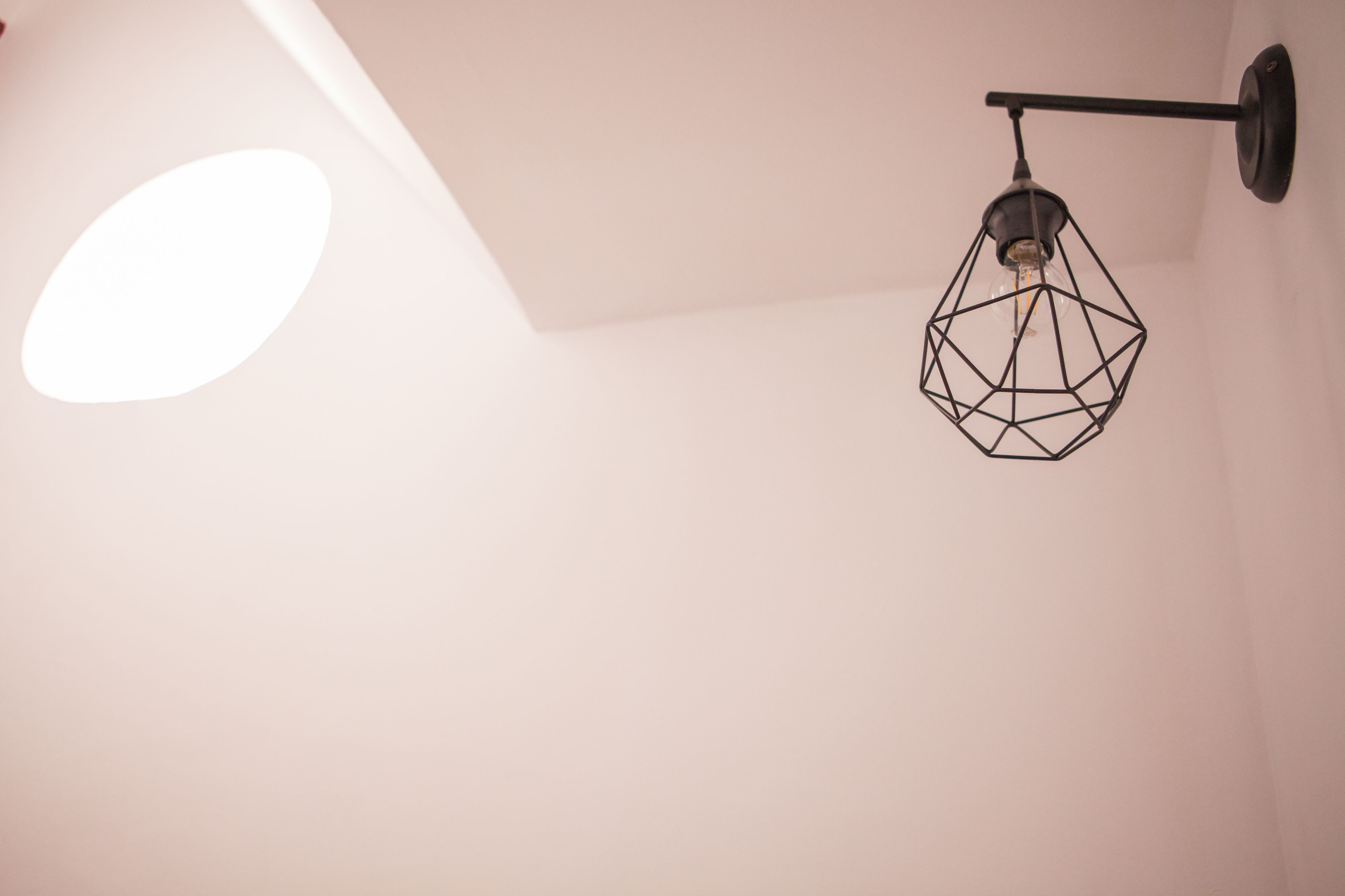 A geometric pendant light fixture on a white wall.