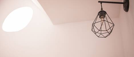 A geometric pendant light fixture on a white wall.
