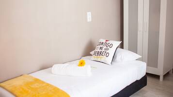 Un dormitorio con cama, armario y una alfombra rosa.