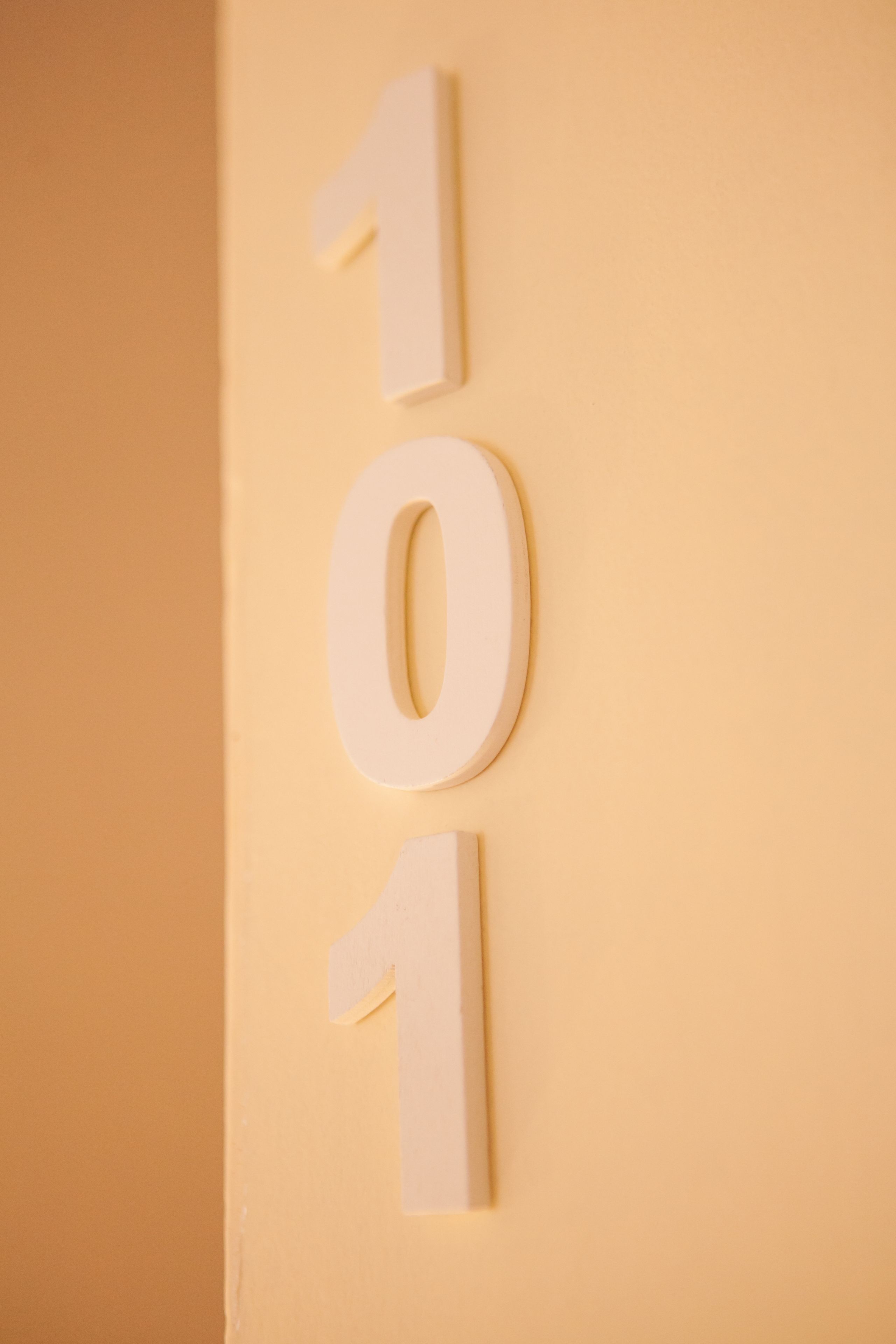 Una pared con el número 101 exhibido en números blancos y tridimensionales.