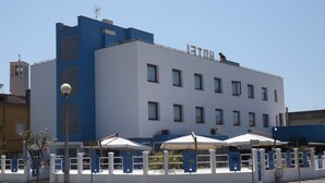 Un edificio moderno con fachada blanca y azul, varias ventanas y techo plano.
