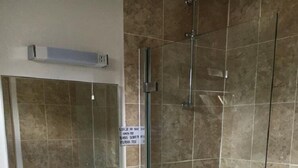 A bathroom with a sink, mirror, and shower. - The Lampet Arms (Banbury)