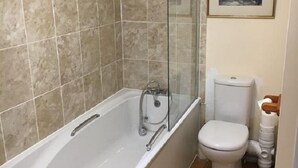 A bathroom with a bathtub, a toilet, and a shower enclosure. - The Lampet Arms (Banbury)