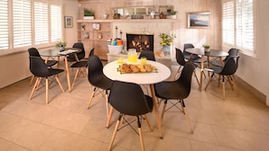 A dining area with a fireplace, wooden walls, and a view of the outdoors. - Carmel Country Inn (Carmel)