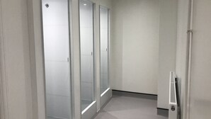 A hallway with frosted glass doors and a white wall. - Bowden Court - Hostel (London)