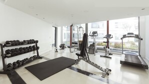 Ein modernes Fitnessstudio mit Trainingsgeräten, Laufband und Kurzhanteln.