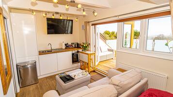 Estúdio panorâmico, 1 cama King | Área de estar | TV de tela plana 49 polegadas com canais via satélite, smart TV, Netflix