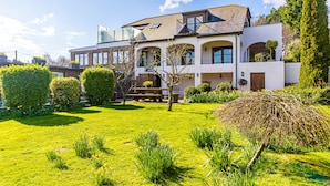 A two-story house with a well-maintained lawn and garden. - Sea View Holiday Flat - Covehurst Bay (Hastings)