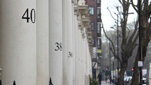 A row of numbered buildings with black iron railings. - Sandeman-Allen House - Hostel (London)
