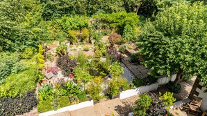 A rooftop garden with various plants and a seating area. - Covehurst Bay Holiday Cottages (Hastings)