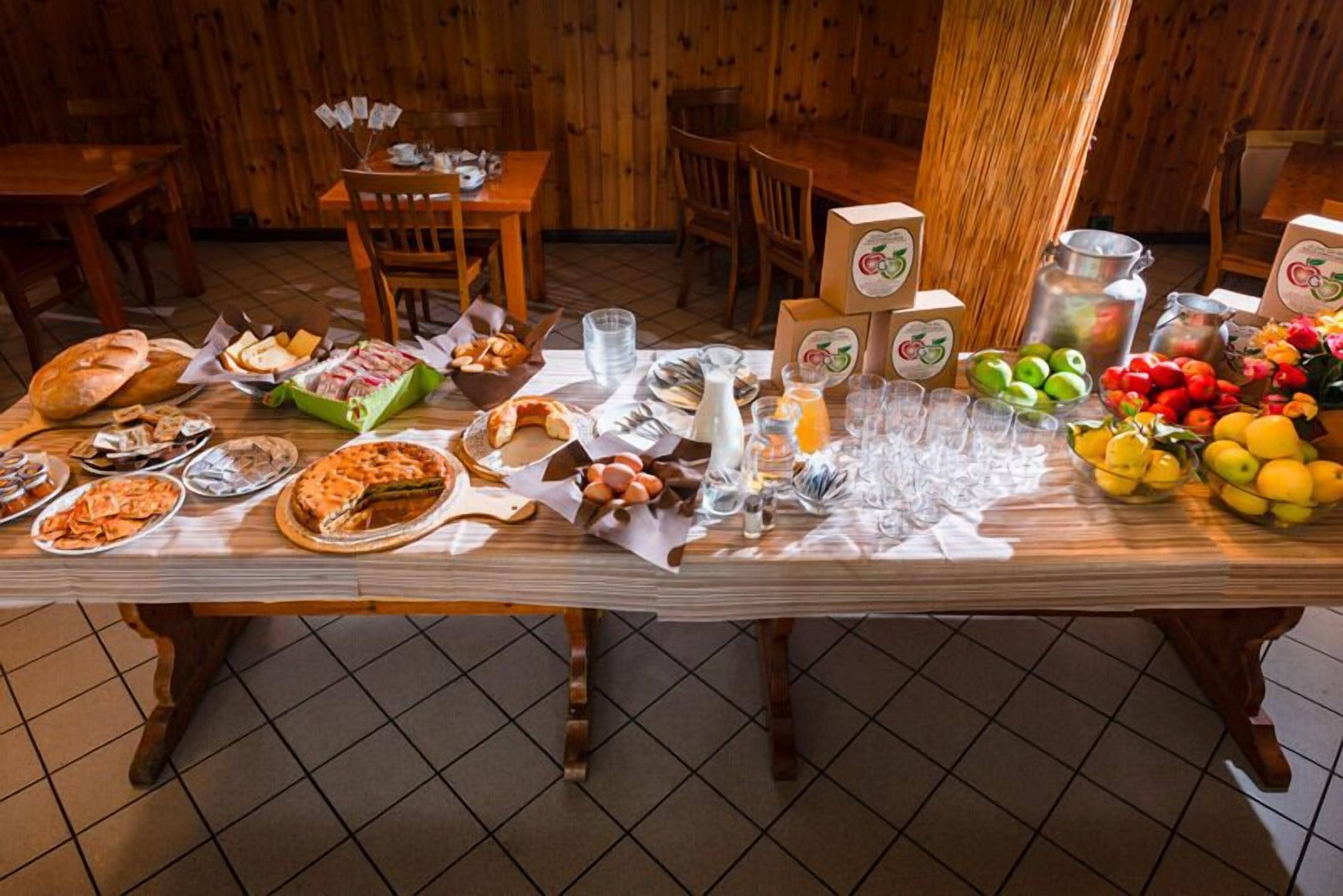 Une table à manger dressée avec divers plats, assiettes et verres, dans un décor intérieur en bois.